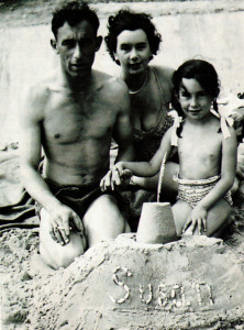 With her name spelled out on the sandcastle the writer, then agreed five, enjoys a holiday with her parents on Hamworthy Beach in 1952.