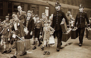 Two bobbies help young evacueess on their way as they prepare to board trains taking them away from London to homes in the north of England.
