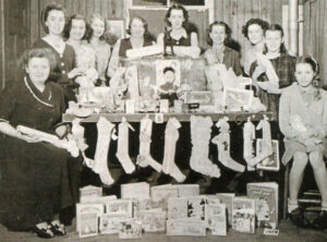 Stockings made and filled by Camp Fire Girls and their leaders ready to be delivered to a children’s home, along with a variety of toys and books donated by the girls in preparation for Christmas in the early 1950s.