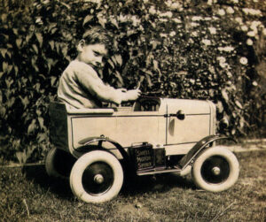 As a child in the 1930s Peter Pitt is photographed in his toy car - and what a car it was - right down to the motor spirit can on the footboard!