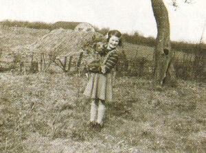 The author with her little dog on the farm, fields in 1953.