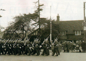 Having just received the Freedom of Entry into the borough, the parading airmen with bayonets fixed pass a cluster of British flags on their return to base. The Central Band was at the head of this procession on March 19 1960.