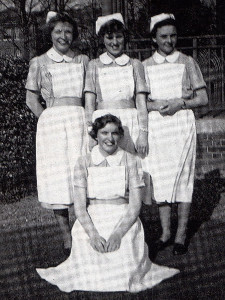 Standing outside the ward mentioned in her accompanying article, the writer is seen kneeling while her twin sister is on her right.