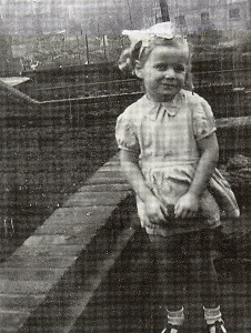 A treasured family album photograph of Olivia among the rooftops of the East End of London.