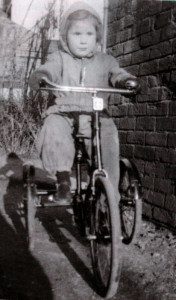 Valerie enjoys a trip on her trike, dressed in her siren suit.